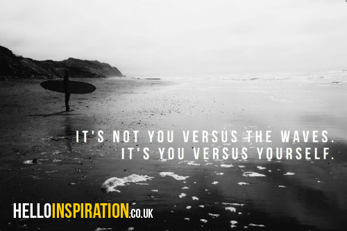 A lone surfer on a beach with 'It's Not You Versus The Waves. It's You Versus Yourself' quote