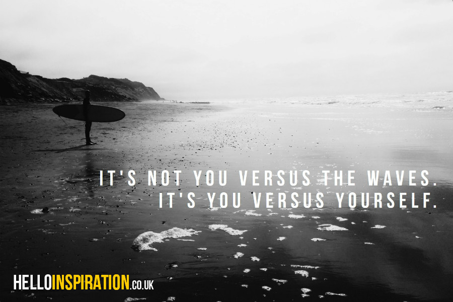 A lone surfer on a beach with 'It's Not You Versus The Waves. It's You Versus Yourself' quote