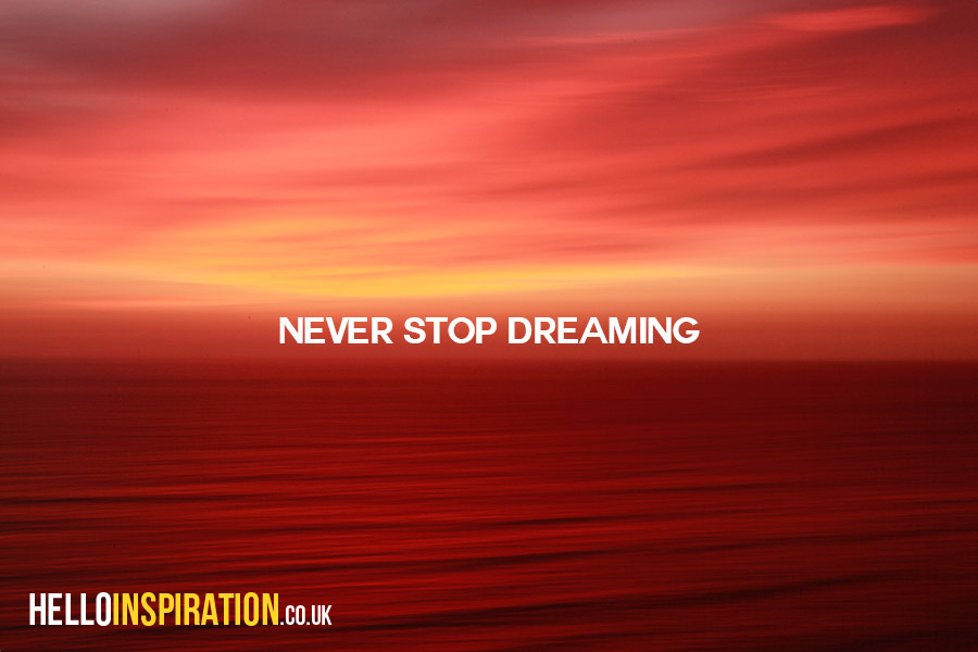 Ocean view with red hue at sunset with 'Never Stop Dreaming' quote