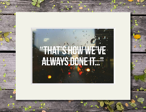 Raindrops on a window with 'That's How We've Always Done It' quote in a crossed out font