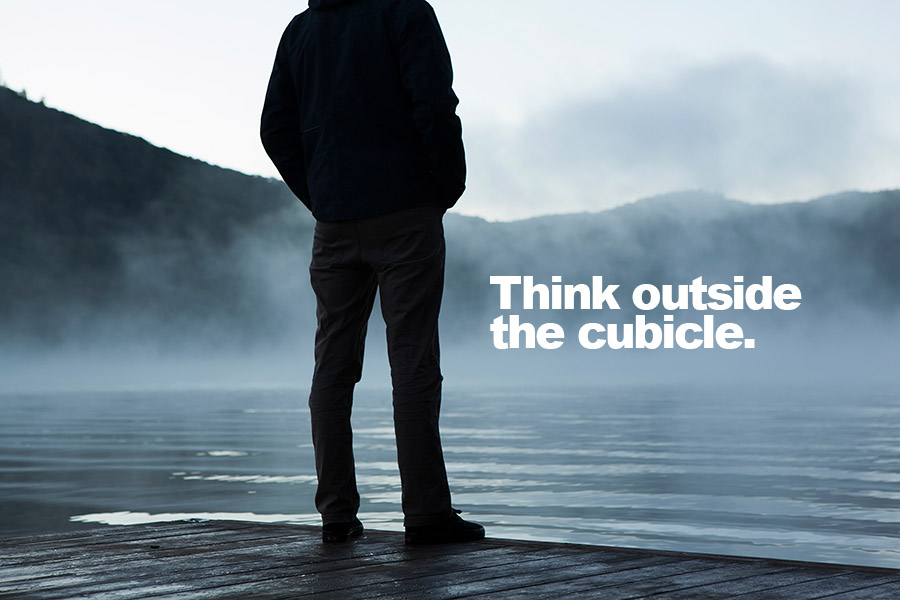 Man standing in front of a tranquil lake with 'Think Outside the Cubicle' quote